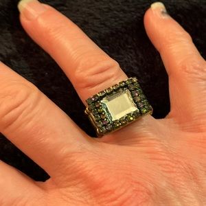 A stretch ring with white square gem and multi colored iridescent rhinestones.